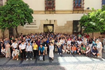 Foto de grupo de cientos de asistentes de un congreso en el patio de un edificio histórico.