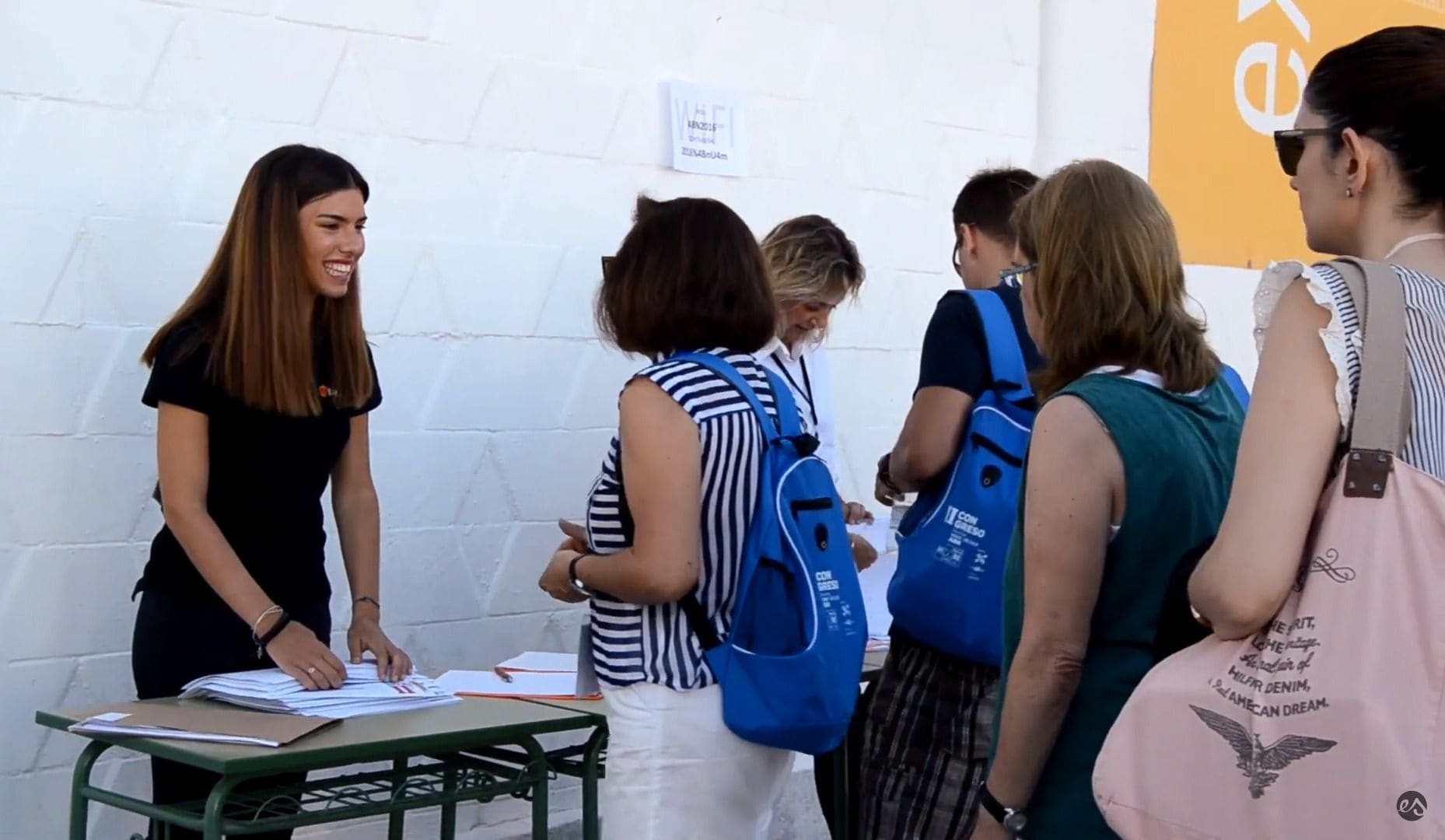 Una persona del equipo atiende la acreditación de los asistentes en un congreso.