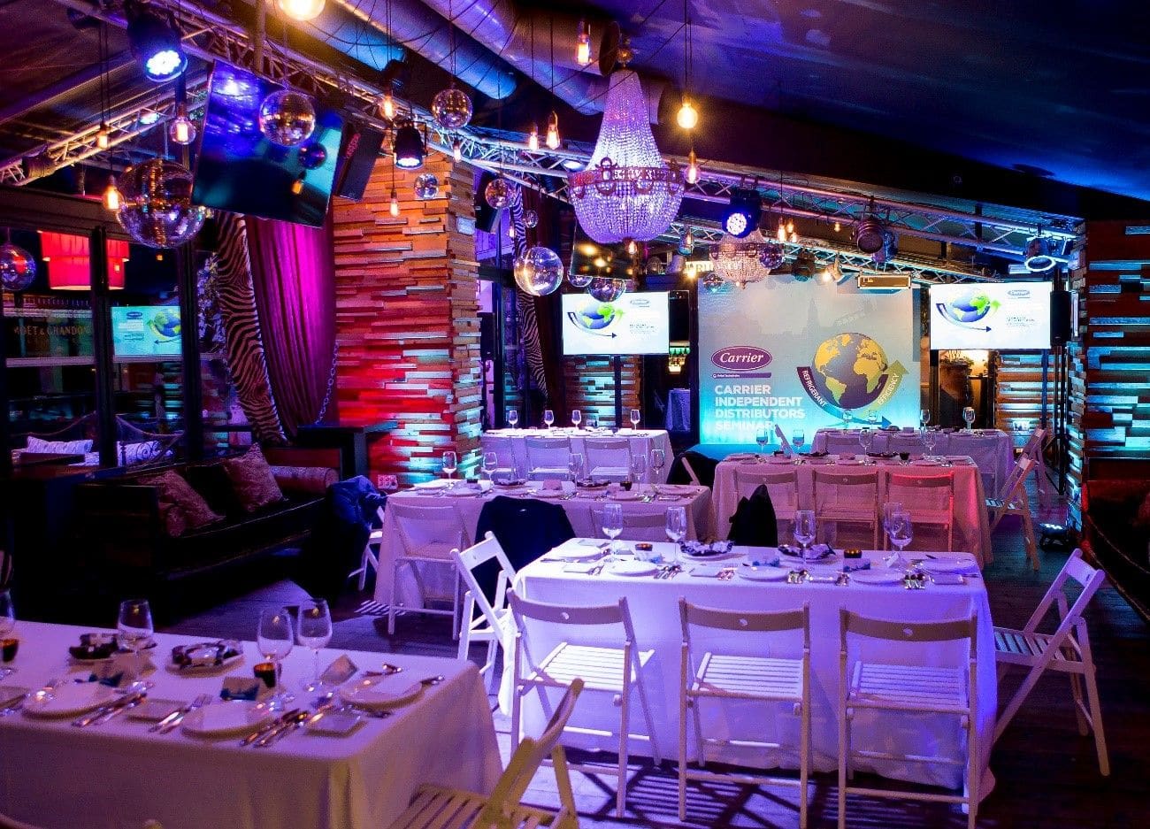 Montaje de una cena de gala de congreso, con escenario e iluminación.
