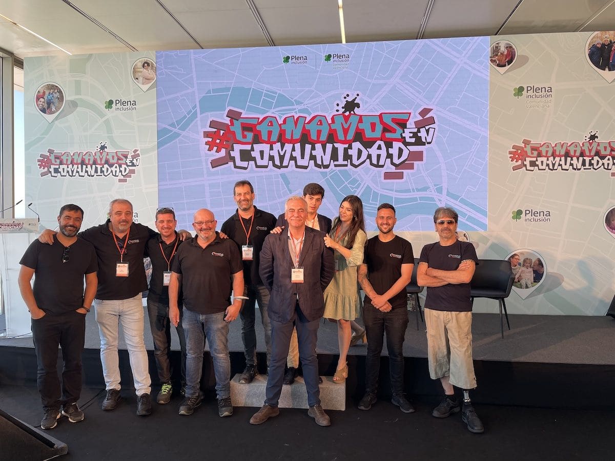 Equipo y participantes sobre el escenario de una jornada de Plena Inclusión.