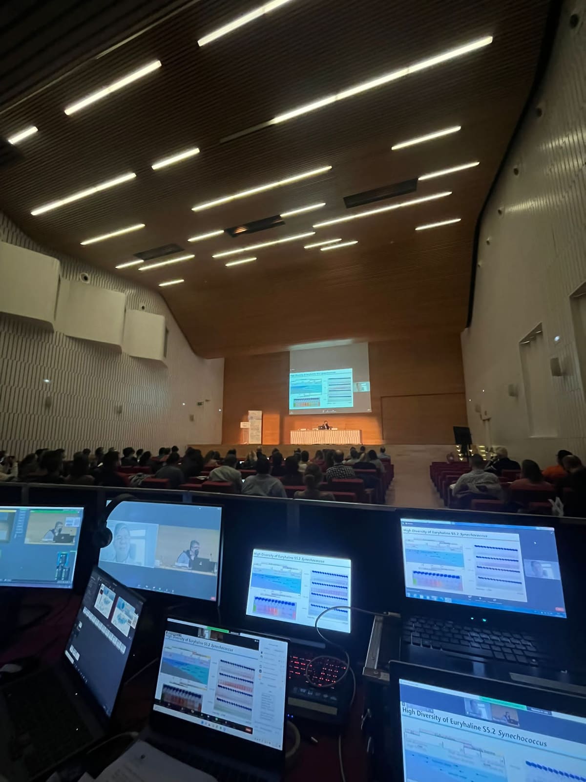 Pantallas de regiduría con el control de proyección y sonido, y la sala al fondo.