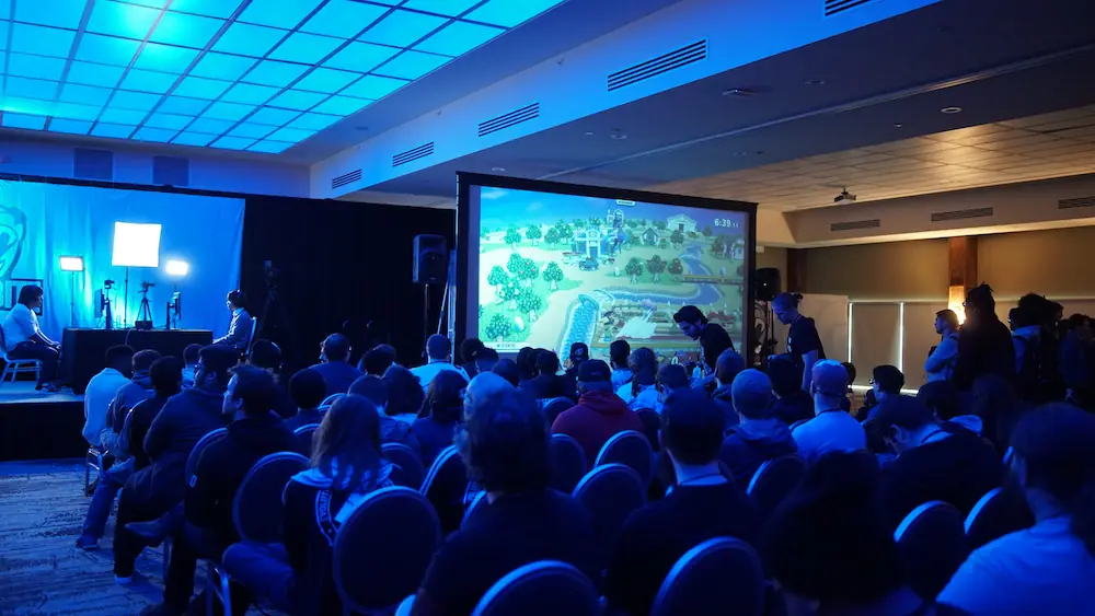 Sala de congresos con el público de espaldas frente a una gran pantalla