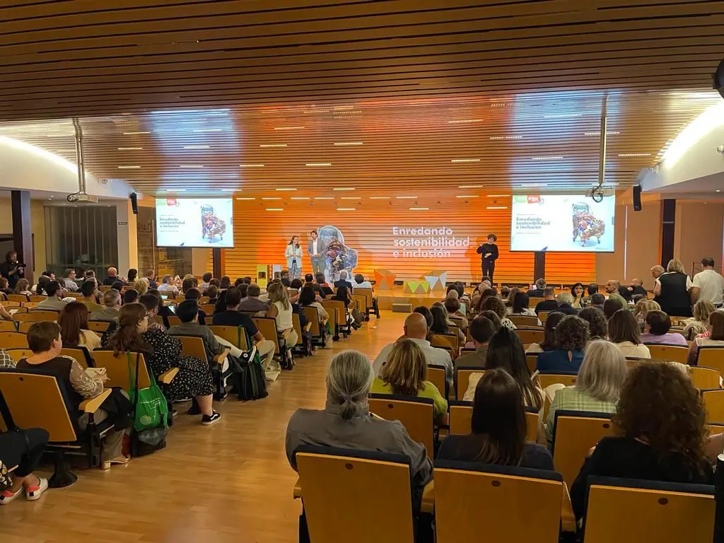 Sala de congresos con butacas naranjas y escenario