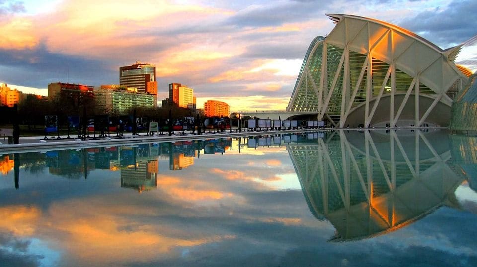 Ciudad de las Artes y las Ciencias de Valencia al atardecer, reflejada en el agua.